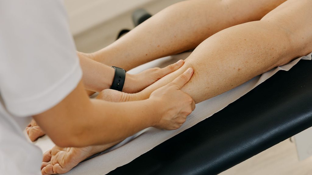 Massage being completed by a massage therapist on a client's calf muscle