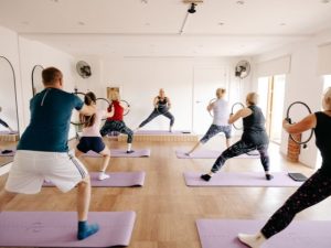 Mat Pilates class lunging using magic circle